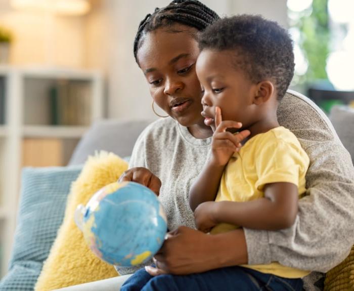 mother and child looking at a globe